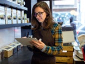 A retail business owner managing a project on their tablet.